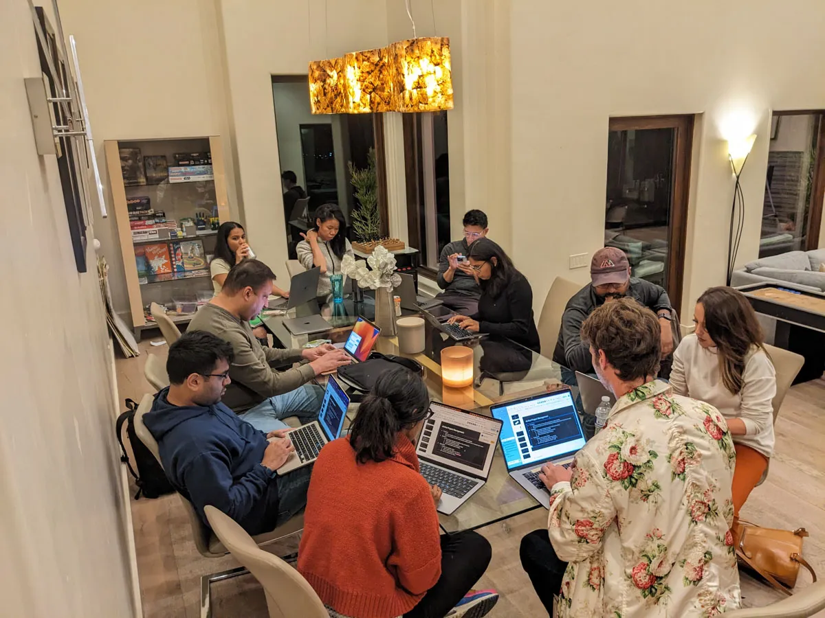 Inception founders sitting around a glass table working hard on their laptops