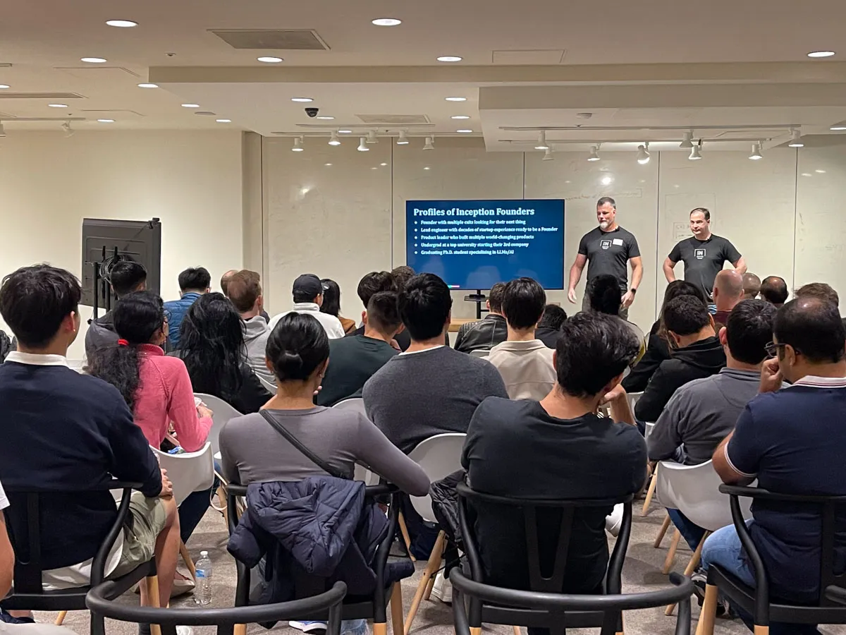 John and Mike presenting at a Demo Day in front of a large crowd of investors and founders