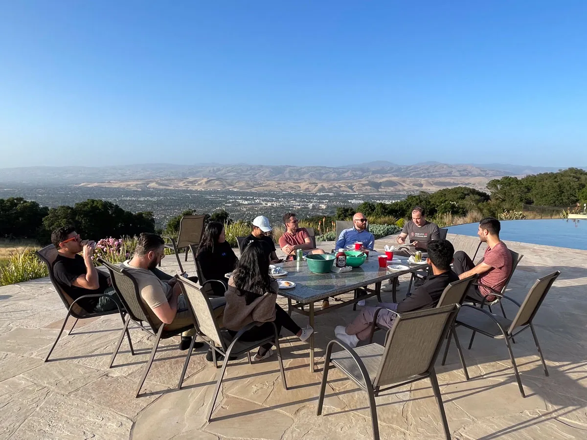 Inception founders sitting around a table outside with a panoramic view of Silicon Valley behind them