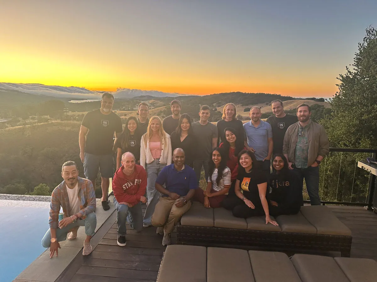 Inception Studio cohort 5 photo of cohort members on a deck with a sunset behind them