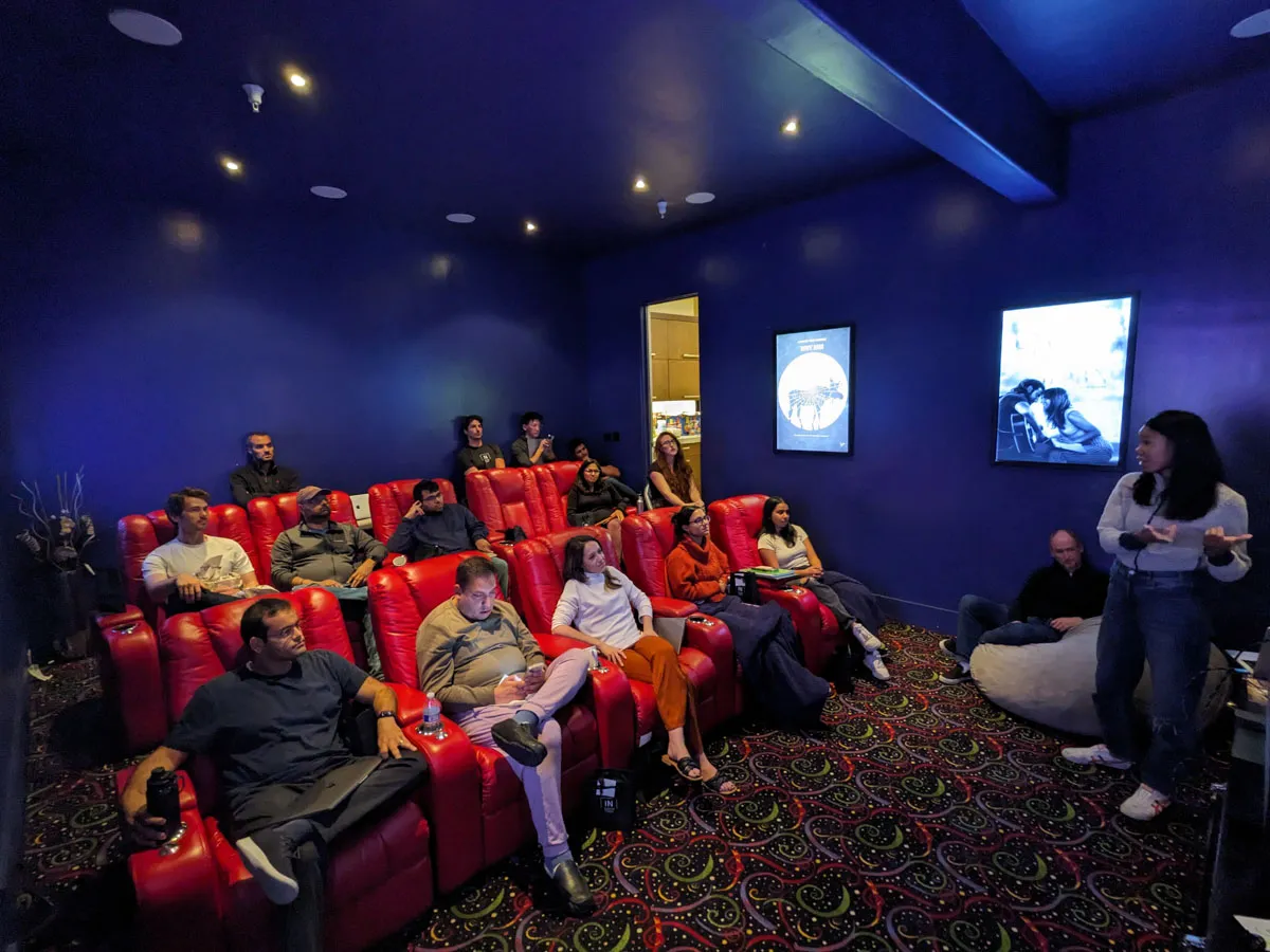 Inception Studio cohort 7 photo of cohort members sitting in a movie theatre room with red chairs