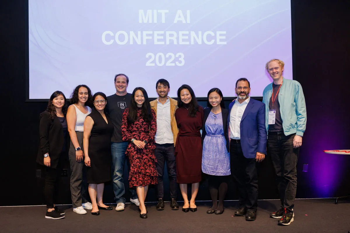 Organizers standing in front of a screen that says MIT AI Conference 2023